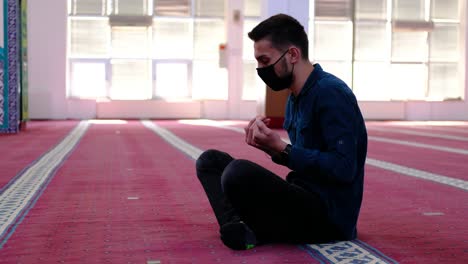 Hombre-Enmascarado-Levantando-Sus-Manos-En-La-Mezquita-Durante-La-Oración