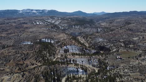Drone-Vista-Sobre-El-Valle-Serpenteante-Contra-Montañas-Nevadas
