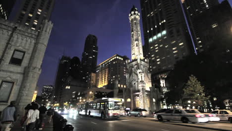 Chicago-busses-pass-water-tower-at-night