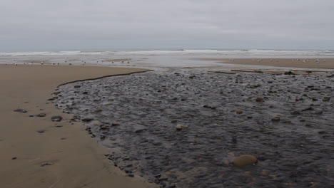 Oregon-coast-stream-flowing-at-low-tide