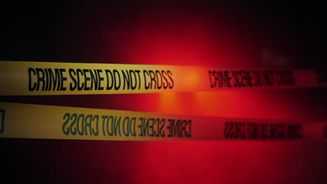 Yellow-ribbons-encloses-crime-scene-lit-by-police-lights