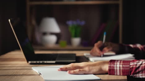 Geschäftsmann-Arbeitet-Zu-Hause-In-Der-Nähe-Von-Laptop-Schreibt-In-Notebook