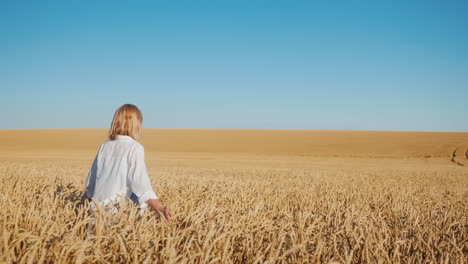A-young-woman-walks-between-endless-wheat-fields-2