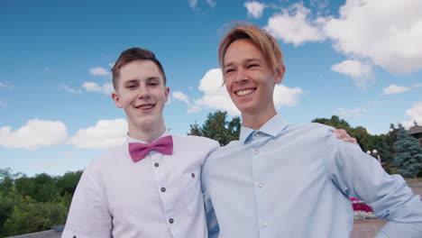 Portrait-of-two-young-high-school-graduates-smiling-and-staring-at-the-camera