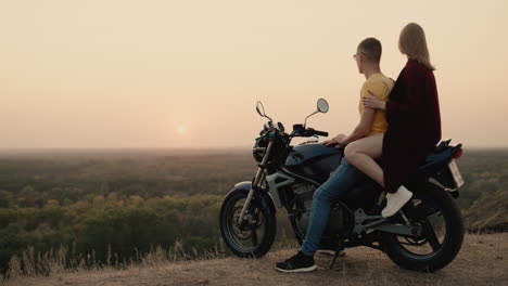 Romantisches-Paar-Sitzt-Auf-Einem-Motorrad-Und-Bewundert-Den-Sonnenuntergang-2