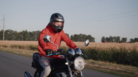A-young-man-rides-a-motorbike-along-corn-fields-1