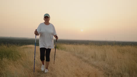 An-Elderly-Woman-With-Nordic-Walking-Sticks-Walks-Forward-Through-A-Scenic-Spot-2