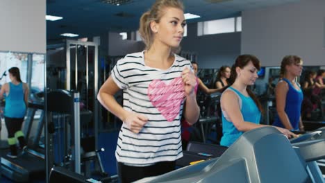 Frau-Trainiert-Im-Fitnessstudio,-Während-Andere-Leute-Im-Hintergrund-Trainieren-2