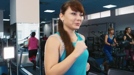 Frau-Trainiert-Im-Fitnessstudio,-Während-Andere-Leute-Im-Hintergrund-Trainieren-5