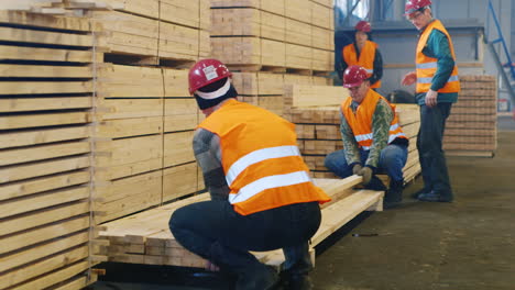 A-group-of-workers-moves-wood-slats-in-stock-2