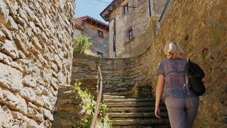 A-tourist-walks-through-the-narrow-streets-of-the-village-of-Rupit-in-Catalonia
