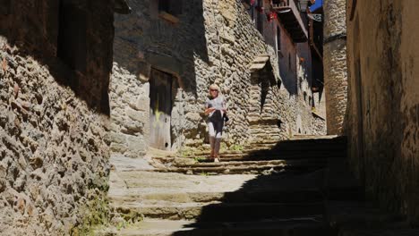 A-tourist-walks-through-the-narrow-streets-of-the-village-of-Rupit-in-Catalonia-2