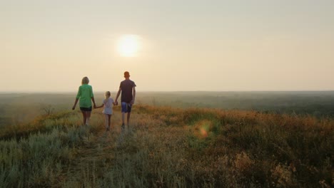 A-family-with-a-child-walks-towards-the-sun
