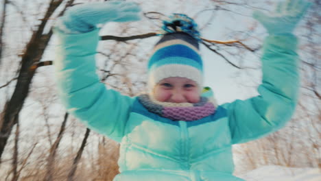 Cheerful-Little-Girl-Goes-On-A-Sled-Claps-His-Hands-Is-Happy-Winter