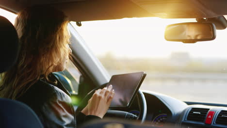 Eine-Junge-Frau-Benutzt-Ein-Tablet-Im-Auto,-Um-An-Einem-Unbekannten-Ort-Zu-Navigieren-Und-Sich-Zu-Orientieren