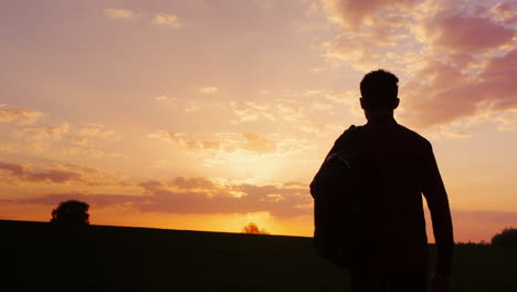 A-Teenager-With-A-Backpack-Looks-Forward-To-The-Sun-And-The-Horizon