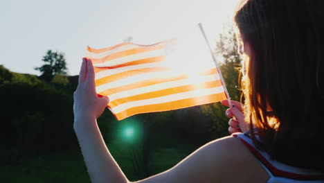 Zwei-Weibliche-Zwillinge-Mit-Einer-Amerikanischen-Flagge-Auf-Blauem-Himmelshintergrund