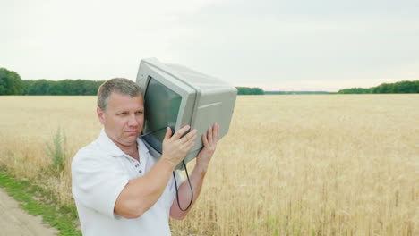 A-Cool-Middle-Aged-Man-Carries-An-Old-Tv-Set-On-His-Shoulder-1