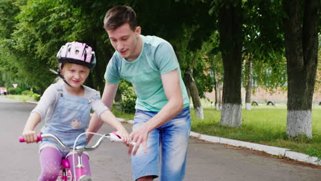 Der-ältere-Bruder-Bringt-Seiner-Schwester-Das-Fahrradfahren-Bei-Die-Ersten-Erfolge-Von-Kindern