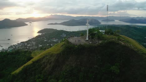 Aerial-View-Of-White-Cross-On-Mount-Tapyas-With-Sunset-Skies-In-Distance