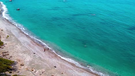 People-walking-on-the-beach-near-Aphrodite`s-Rock-in-Cyprus