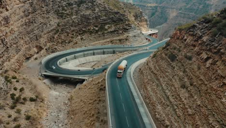 Aerial-Of-Tanker-And-Cars-Driving-On-Winding-CPEC-Road-At-Fort-Munro-In-Sulaiman-Mountains