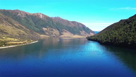 Aerial-View-of-People-Water-Skiing-on-Beautiful-Lake-Taylor,-New-Zealand---Dolly-In-Shot