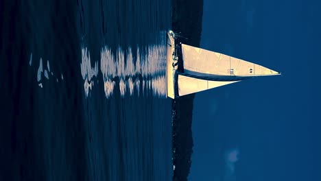 Nocturnal-colored-footage-of-small-boat-sailing-in-calm-open-lake-waters