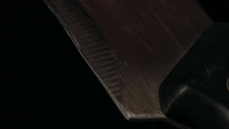 Kitchen-knife-close-up,-black-background,-slow-camera-tilt