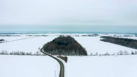 Drone-flying-back-over-a-lonely-road-in-winter