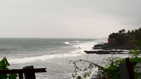 Ocean-waves-hitting-Soka-beach-of-Bali-island,-static-distance-shot-on-a-moody-day