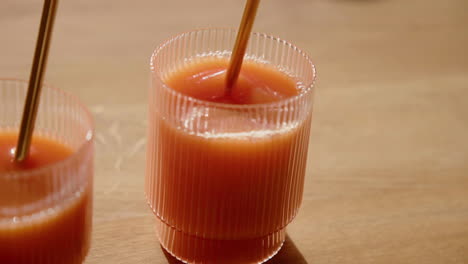 A-Orange-Cold-Pressed-Juice-gets-stirred-with-a-metal-straw-in-a-drinking-glass-during-Detox-Cleanse-Slow-Motion