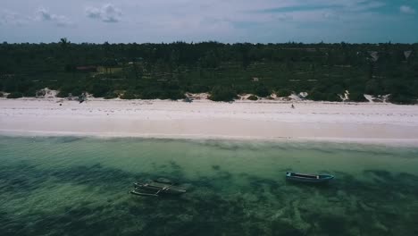 Buttery-soft-aerial-flight-slowly-sinking-down-drone-shot-of-a-empte-lonely-paradise-white-sand-dream-beach-on-Zanzibar,-Africa-at-corona-lockdown