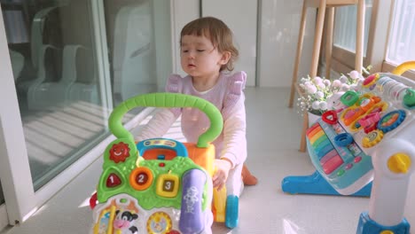 Süßes-Kleinkind-Baby,-Das-Mit-Interaktivem-Lernrollator-Spielt-Und-Auf-Dem-Balkon-Eduierbar-Ist,-Um-Spielzeug-Zu-Schieben-Und-Zu-Ziehen