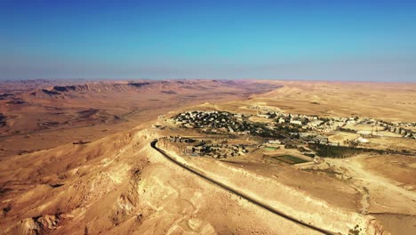 Beautiful-village-of-Makhtesh-Ramon-built-with-great-views-over-the-dark-colored-Mitzpe-Ramon-in-Israel-on-a-sunny-day