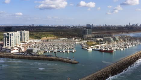 Beautiful-giant-marina-with-a-lot-of-luxury-yachts-and-sailing-boats-docked-in-the-port-of-Herzeliya-in-Israel-on-a-sunny-day-with-in-the-background-the-city-skyline