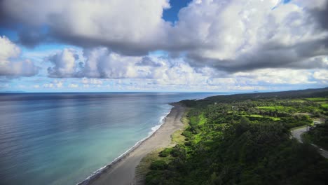 Blue-waters-crashing-on-the-shores-of-a-pacific-island-with-clouds-looming-above