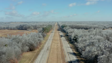 Static-aerial-view-over-long-rural-interstate-highway-road-with-trucks,-4K
