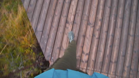 POV-shot-of-a-person-walking-on-a-boardwalk-over-a-marsh-in-Iceland