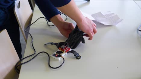 Engineer-working-on-technical-glove-that-allows-people-to-speak