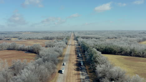 Descending-aerial-over-remote-stretch-of-interstate-highway-with-trees,-4K