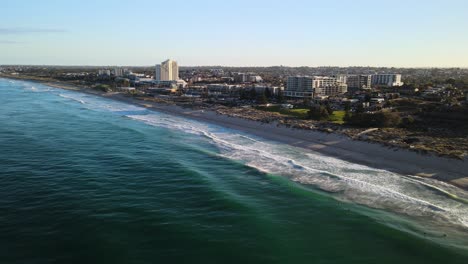 Aerial-fly-by-of-Scarborough-Beach,-Perth-at-sunrise