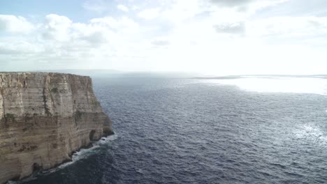 Slow-Panoramic-View-of-Ta-Cenc-Cliffs-and-Blue-Mediterranean-Sea-with-Bright-Sun-Shining-on-Winter-Day