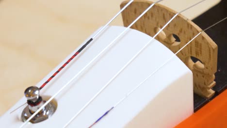 Nahaufnahme-Eines-Fingers,-Der-Die-Saiten-Einer-3D-gedruckten-Geige-Berührt