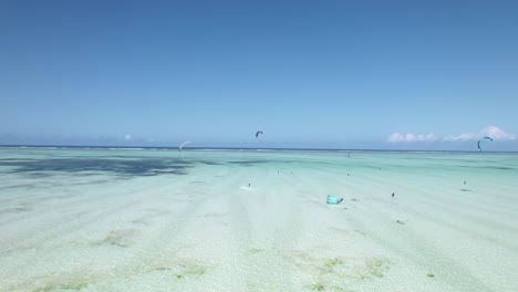 Kiteboarders-surf-over-tropical-beach-shoals-on-bright,-sunny-day