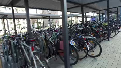 Fast-camera-movement-behind-parked-bycicles-under-roof-in-germany