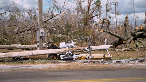 Massive-power-polls-are-laying-on-the-side-of-the-road-after-the-recent-hurricane