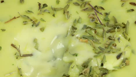 Macro-shot-of-spoon-mixing-homemade-mayo-seasoned-with-parsley