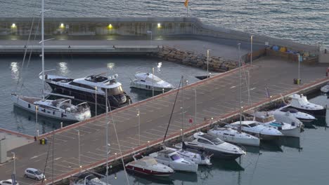 Blanes-city-on-the-Costa-Brava-of-Spain,-tourist-beach-town-sunset-and-night-images-marina-and-fishing-port-moored-boats
