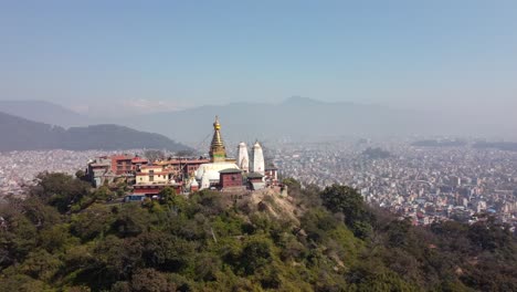 Ein-Blick-Auf-Die-Swayambhunath-Stupa-Auf-Der-Spitze-Eines-Hügels-Mit-Der-Stadt-Kathmandu,-Nepal-Und-Den-Himalaya-bergen-Im-Hintergrund